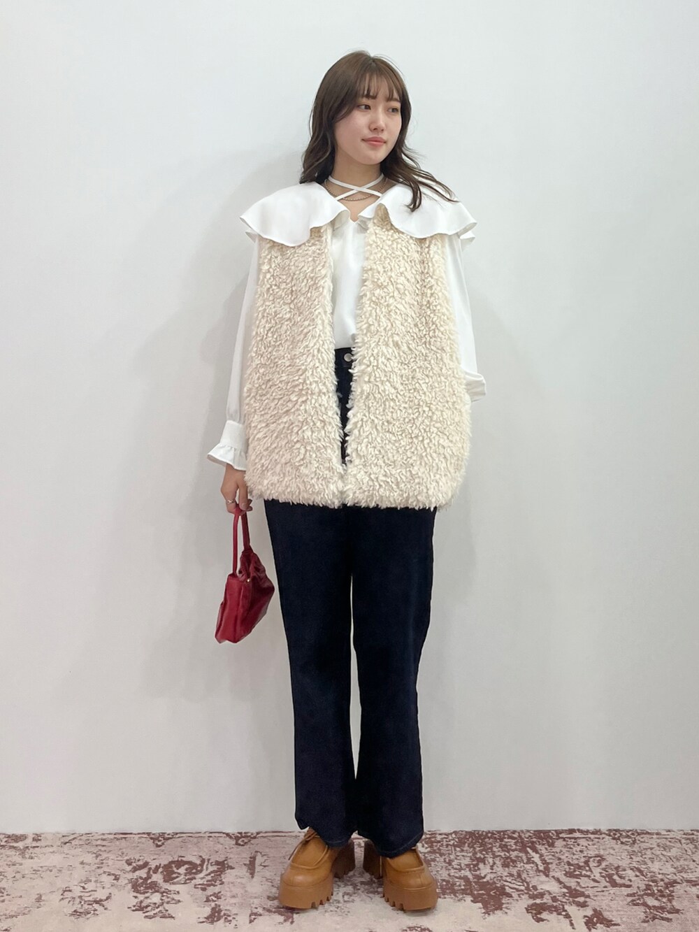 ブラック系のスニーカー、ホワイト系のベスト、ブラック系のTシャツ/カットソーを着用したレディースの夏コーディネートの2枚目の写真