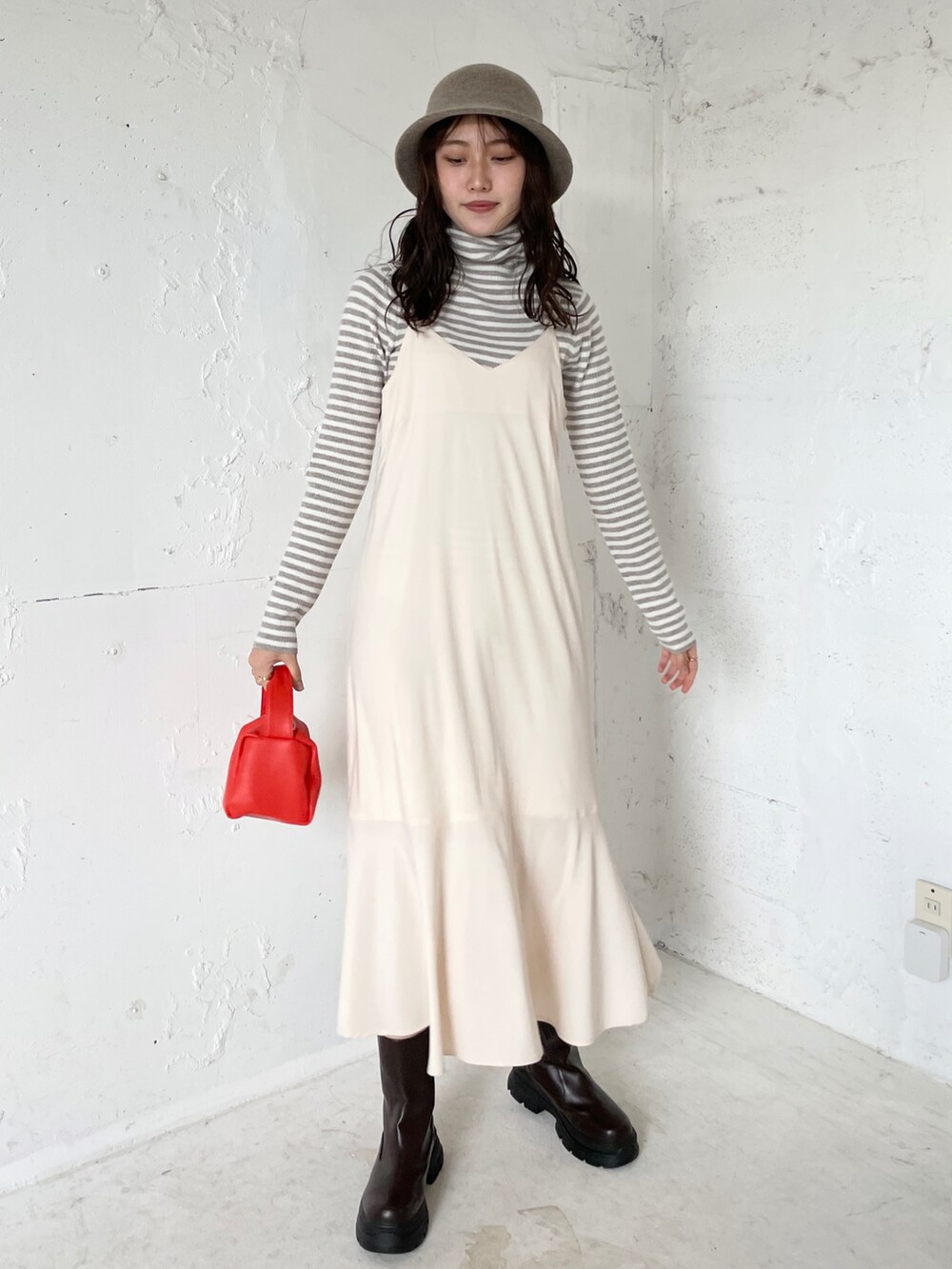 ベージュ系のニット/セーター、ブラック系のスニーカー、ホワイト系のTシャツ/カットソーを着用したレディースの秋コーディネートの3枚目の写真