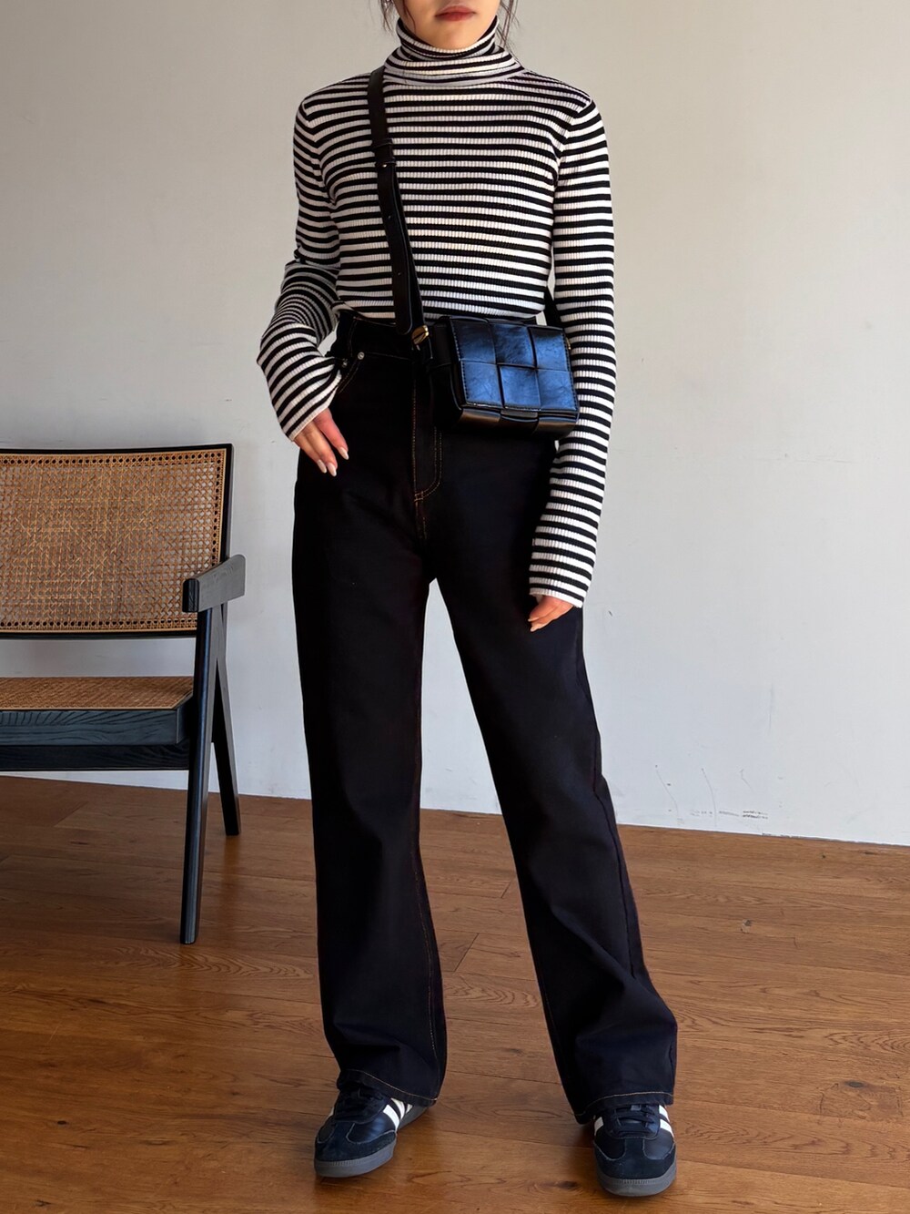 ホワイト系のニット/セーター、ブラック系のデニムパンツ、ブラック系のスニーカーを着用したレディースの冬コーディネートの2枚目の写真