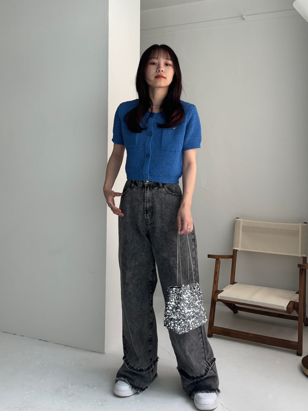 グレー系のデニムパンツ、ブルー系のカーディガン/ボレロ、ホワイト系のスニーカーを着用したレディースの夏コーディネートの3枚目の写真