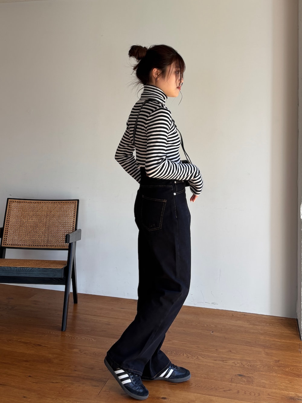 ホワイト系のニット/セーター、ブラック系のデニムパンツ、ブラック系のスニーカーを着用したレディースの冬コーディネートの3枚目の写真