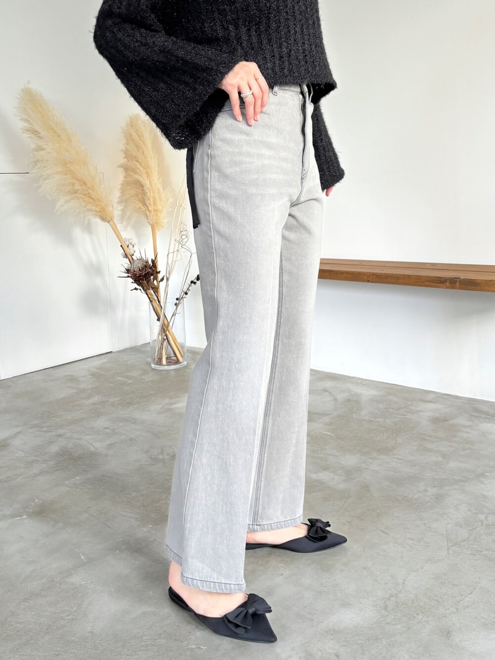 グレー系のデニムパンツ、ブラック系のニット/セーター、ベージュ系のハットを着用したレディースの冬コーディネートの5枚目の写真