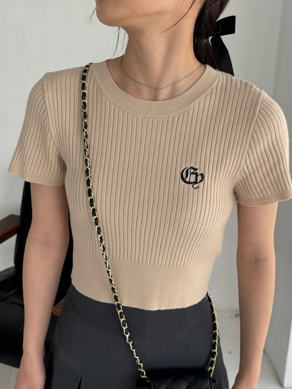 グレー系のスカート、ベージュ系のニット/セーター、ブラウン系のブーツを着用したレディースの秋コーディネートの4枚目の写真