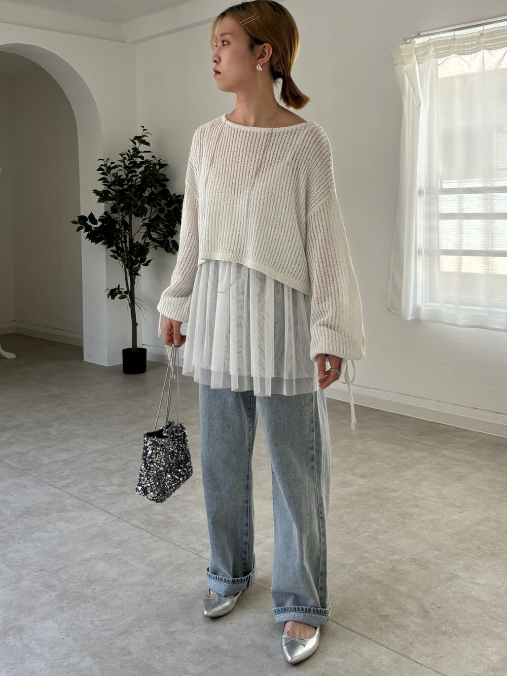 ホワイト系のシャツ/ブラウス、ホワイト系のニット/セーター、ブルー系のデニムパンツを着用したレディースの春コーディネートの3枚目の写真