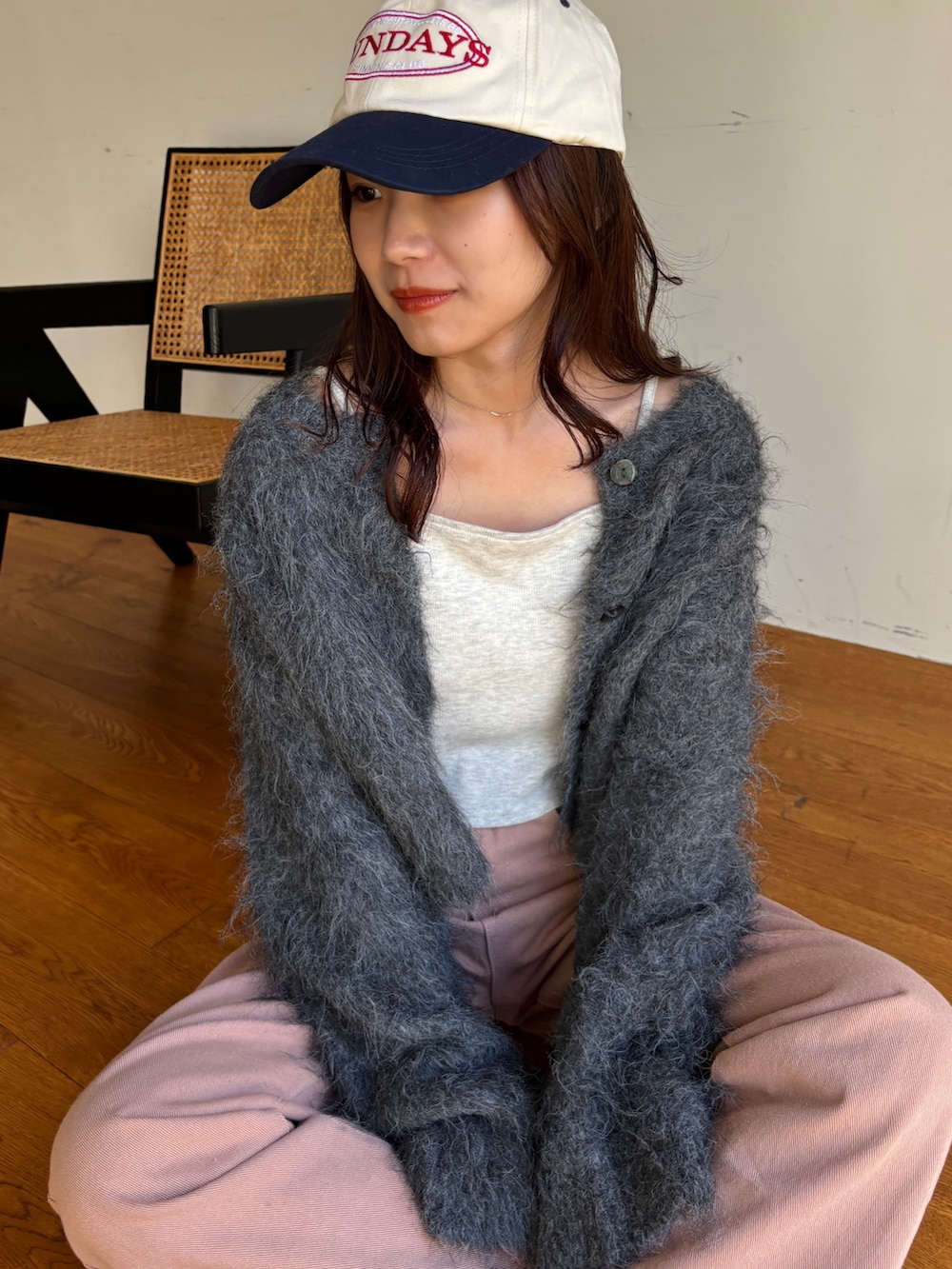 グレー系のカーディガン/ボレロ、ベージュ系のキャミソール、ピンク系のデニムパンツを着用したレディースの冬コーディネートの3枚目の写真