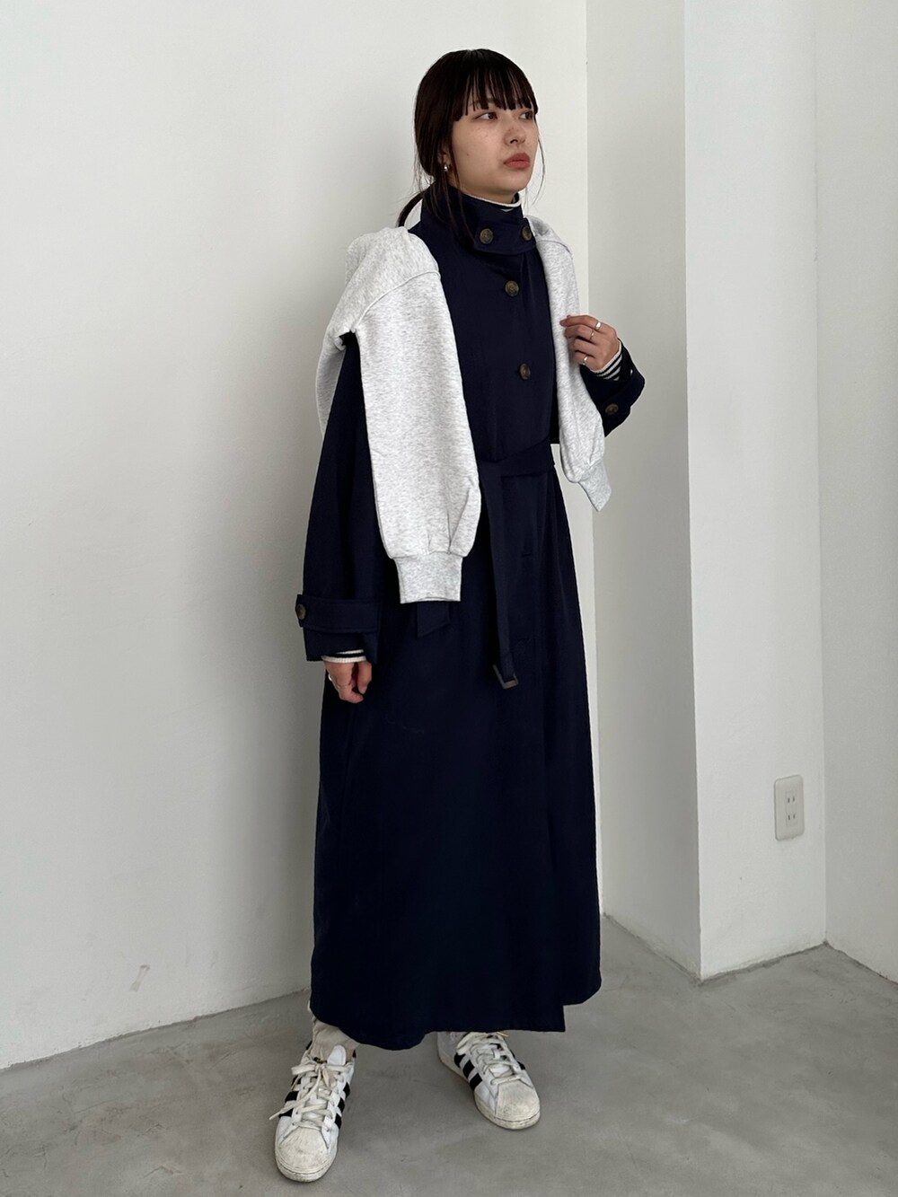 ブルー系のステンカラーコート、ホワイト系のカーゴパンツ、ホワイト系のスニーカーを着用したレディースの冬コーディネートの3枚目の写真