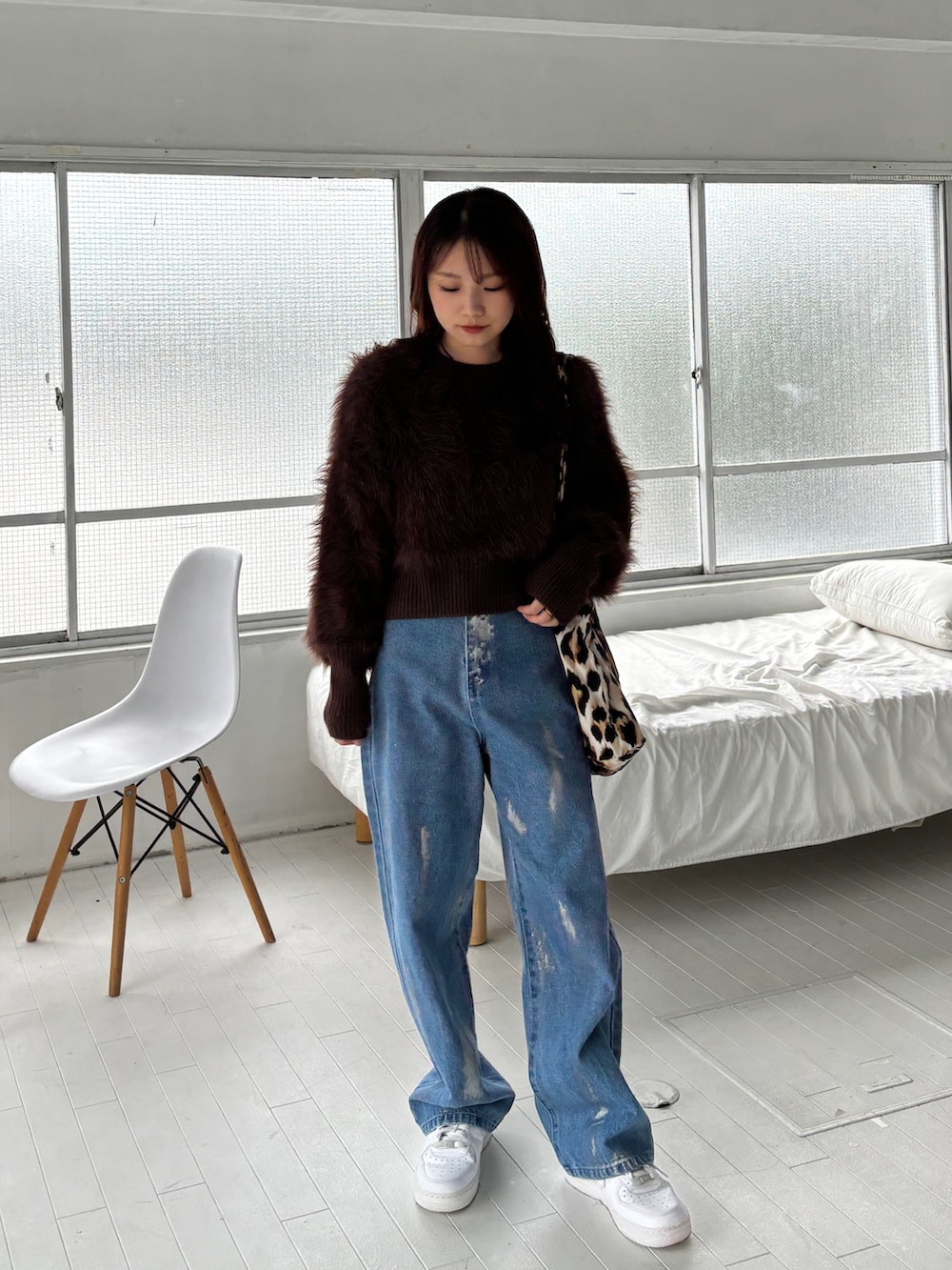 ブラウン系のニット/セーター、ブルー系のデニムパンツ、ホワイト系のスニーカーを着用したレディースの秋コーディネートの2枚目の写真