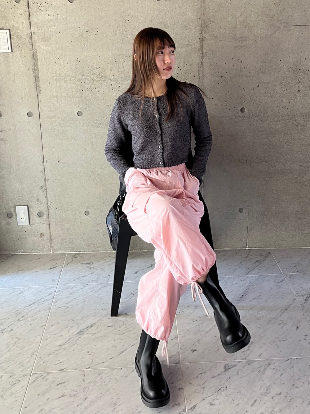 グレー系のカーディガン/ボレロ、ピンク系のカーゴパンツ、ブラック系のブーツを着用したレディースの春コーディネートの3枚目の写真