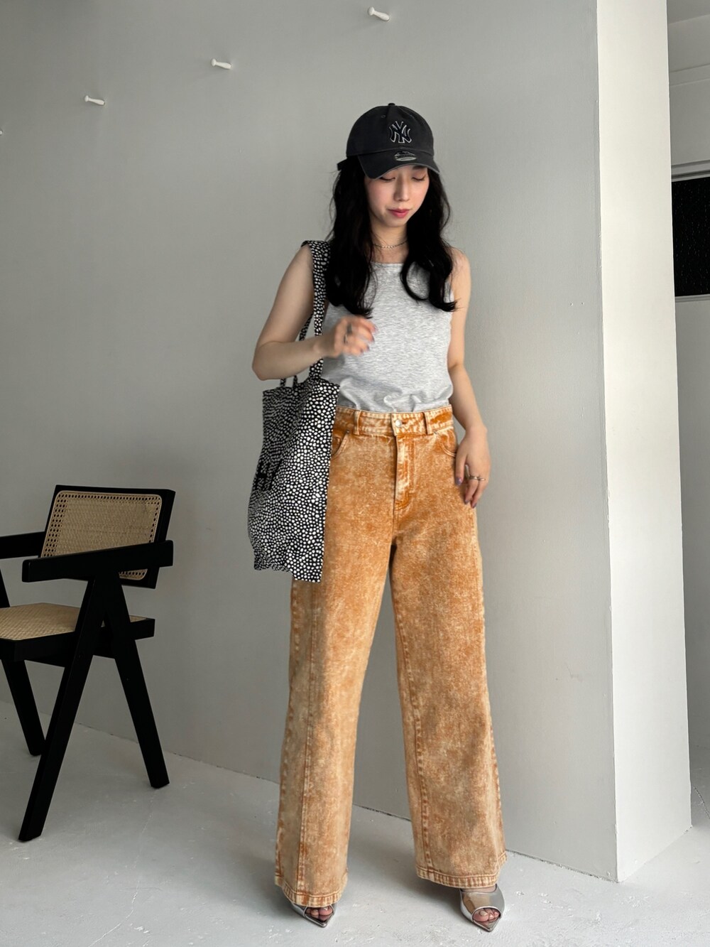 オレンジ系のデニムパンツ、ベージュ系のタンクトップ、シルバー系のサンダルを着用したレディースの夏コーディネートの3枚目の写真