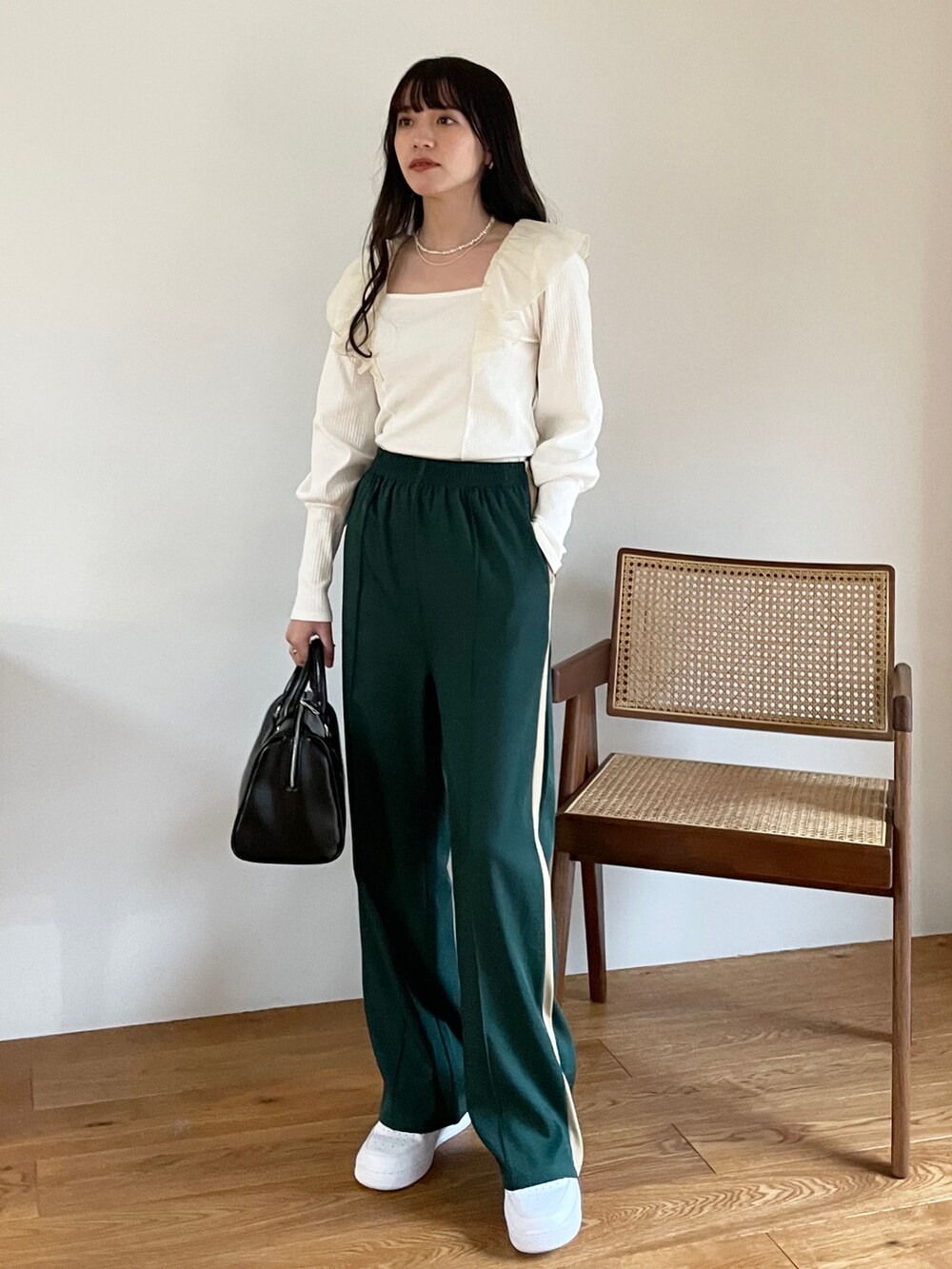 ブルー系のTシャツ/カットソー、グリーン系のスラックス、ホワイト系のスニーカーを着用したレディースの冬コーディネートの3枚目の写真
