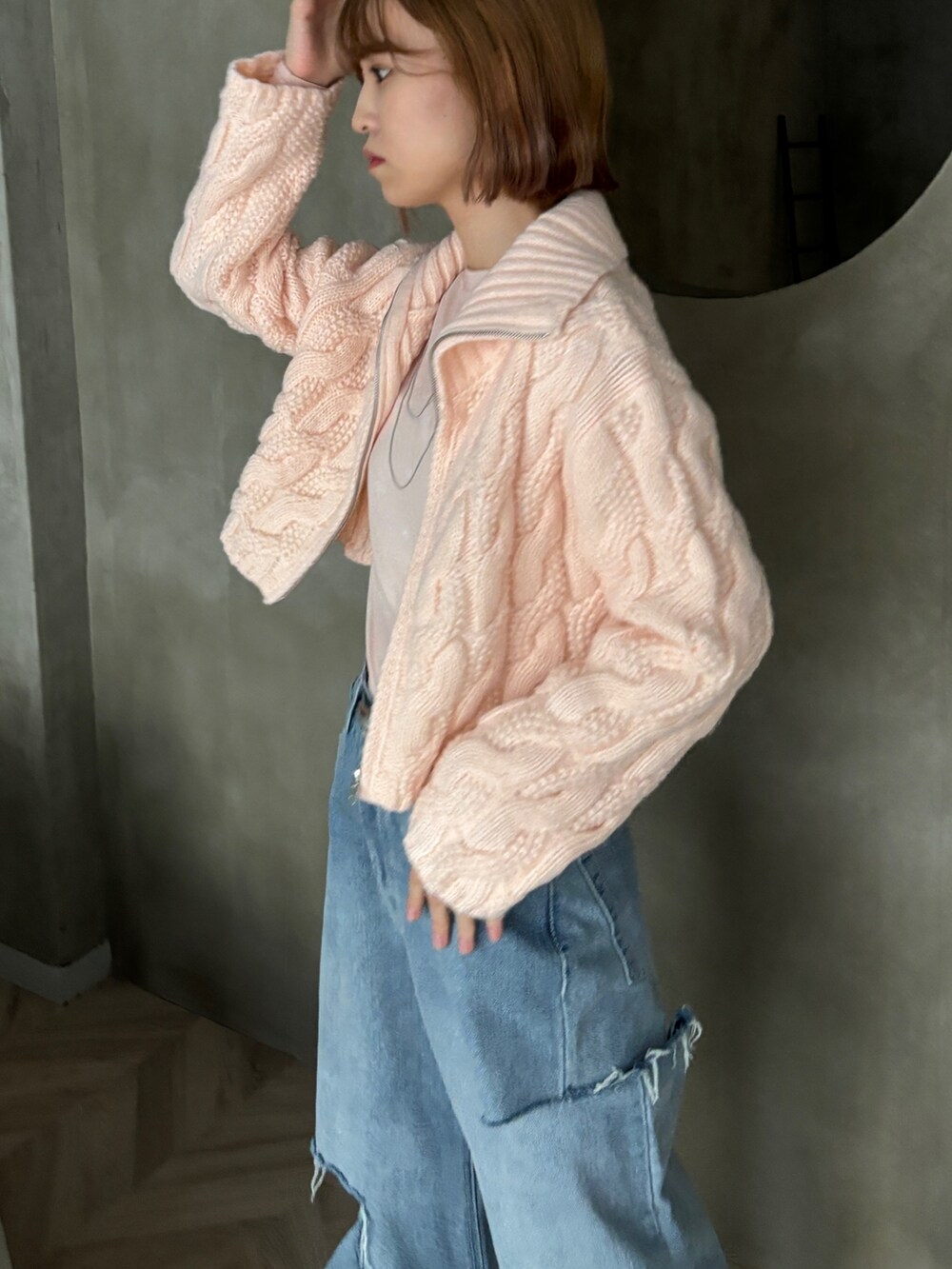 ピンク系のカーディガン/ボレロ、ピンク系のTシャツ/カットソー、ブルー系のデニムパンツを着用したレディースの冬コーディネートの4枚目の写真