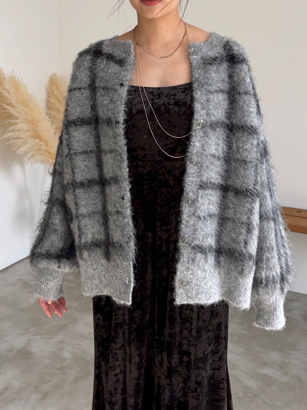 ブラック系のワンピース、グレー系のカーディガン/ボレロ、ブラック系のブーツを着用したレディースの冬コーディネートの5枚目の写真