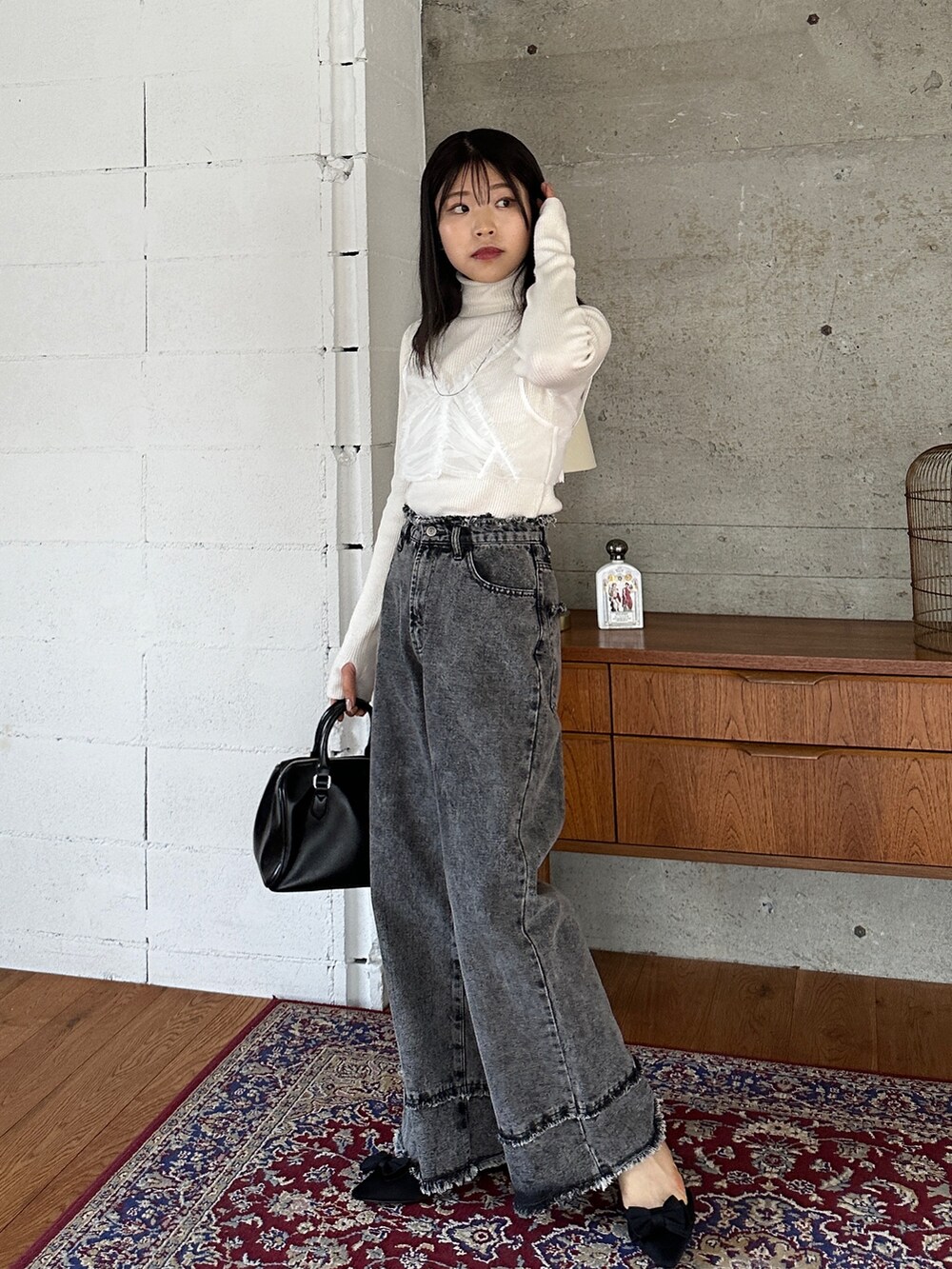 ホワイト系のニット/セーター、ホワイト系のシャツ/ブラウス、グレー系のデニムパンツを着用したレディースの秋コーディネートの2枚目の写真