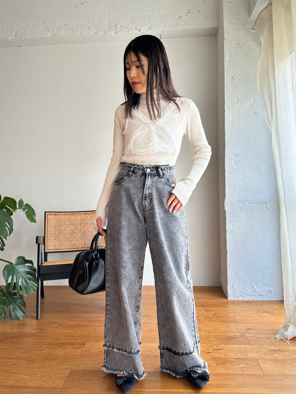 ホワイト系のニット/セーター、ホワイト系のシャツ/ブラウス、グレー系のデニムパンツを着用したレディースの秋コーディネートの4枚目の写真