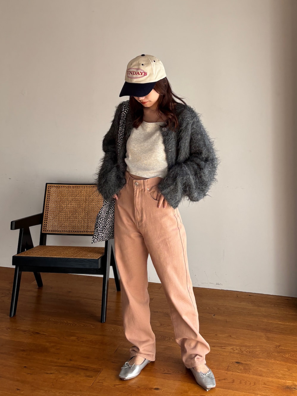 グレー系のカーディガン/ボレロ、ベージュ系のキャミソール、ピンク系のデニムパンツを着用したレディースの冬コーディネートの2枚目の写真