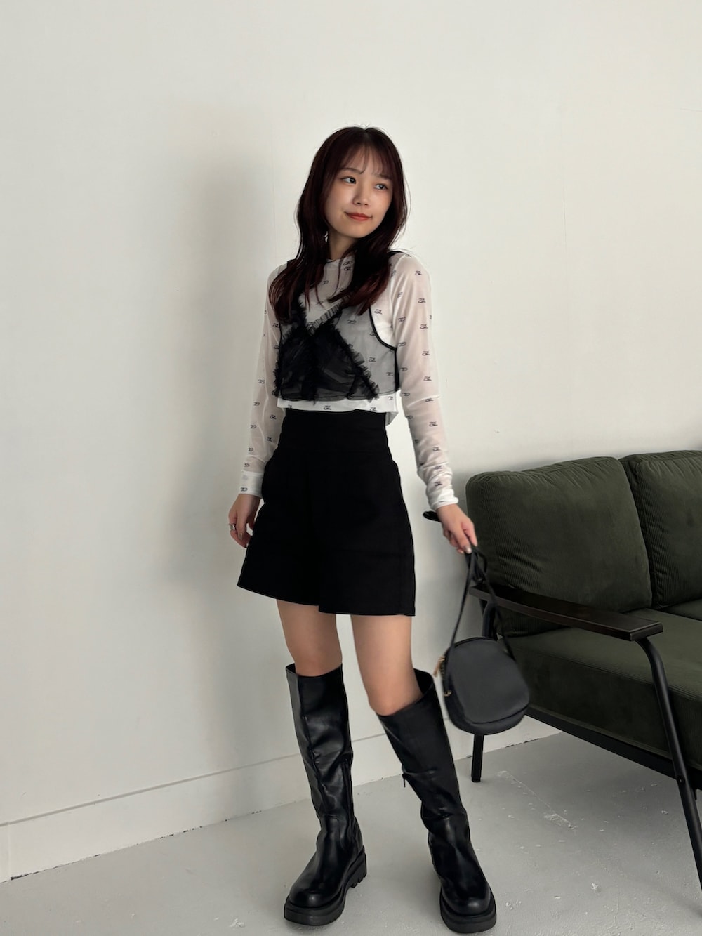 ブラック系のチノパンツ、ブラック系のスニーカー、ホワイト系のTシャツ/カットソーを着用したレディースの夏コーディネートの2枚目の写真