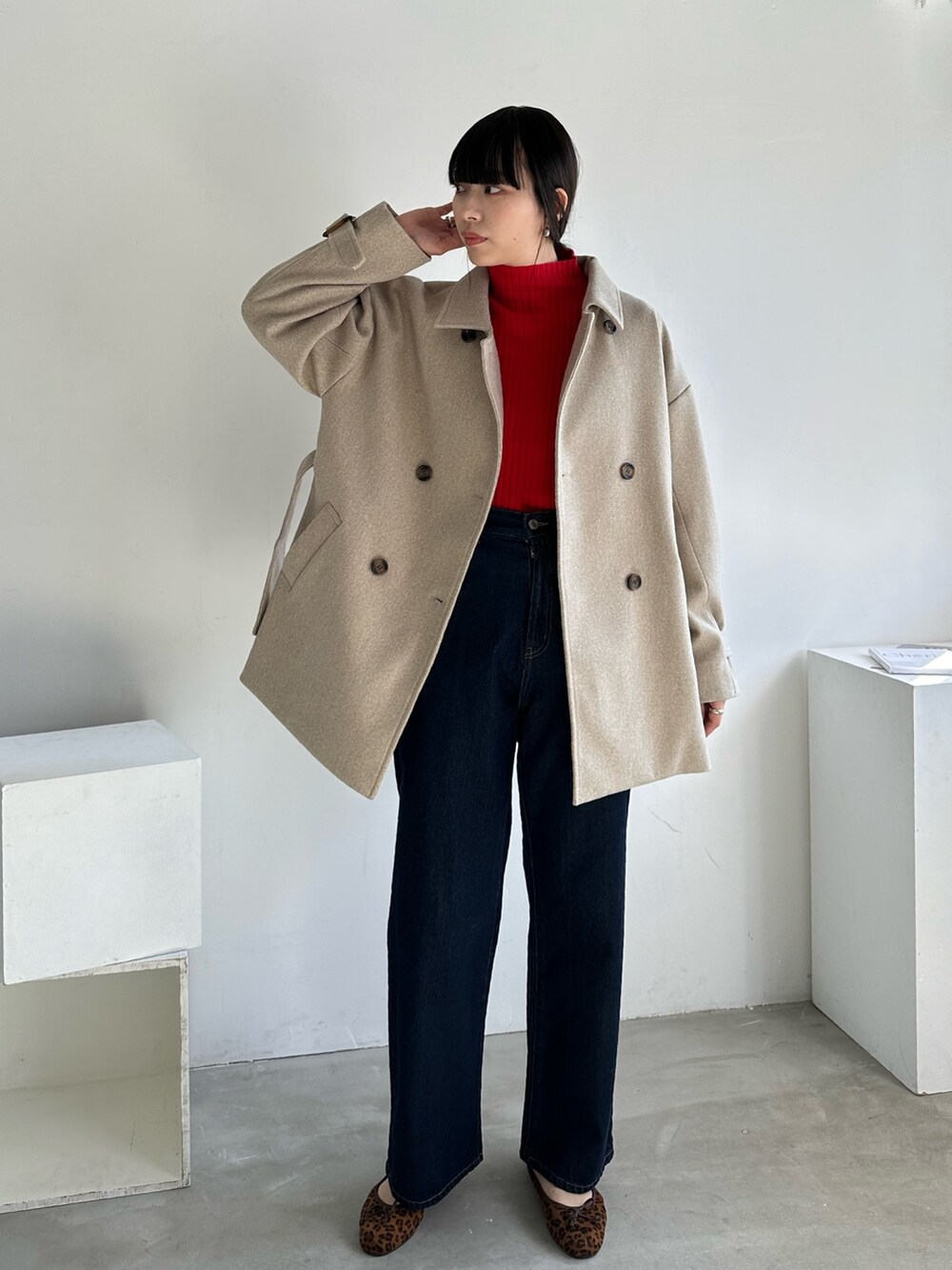 レッド系のニット/セーター、ベージュ系のその他アウター、ブラック系のスニーカーを着用したレディースの冬コーディネートの3枚目の写真