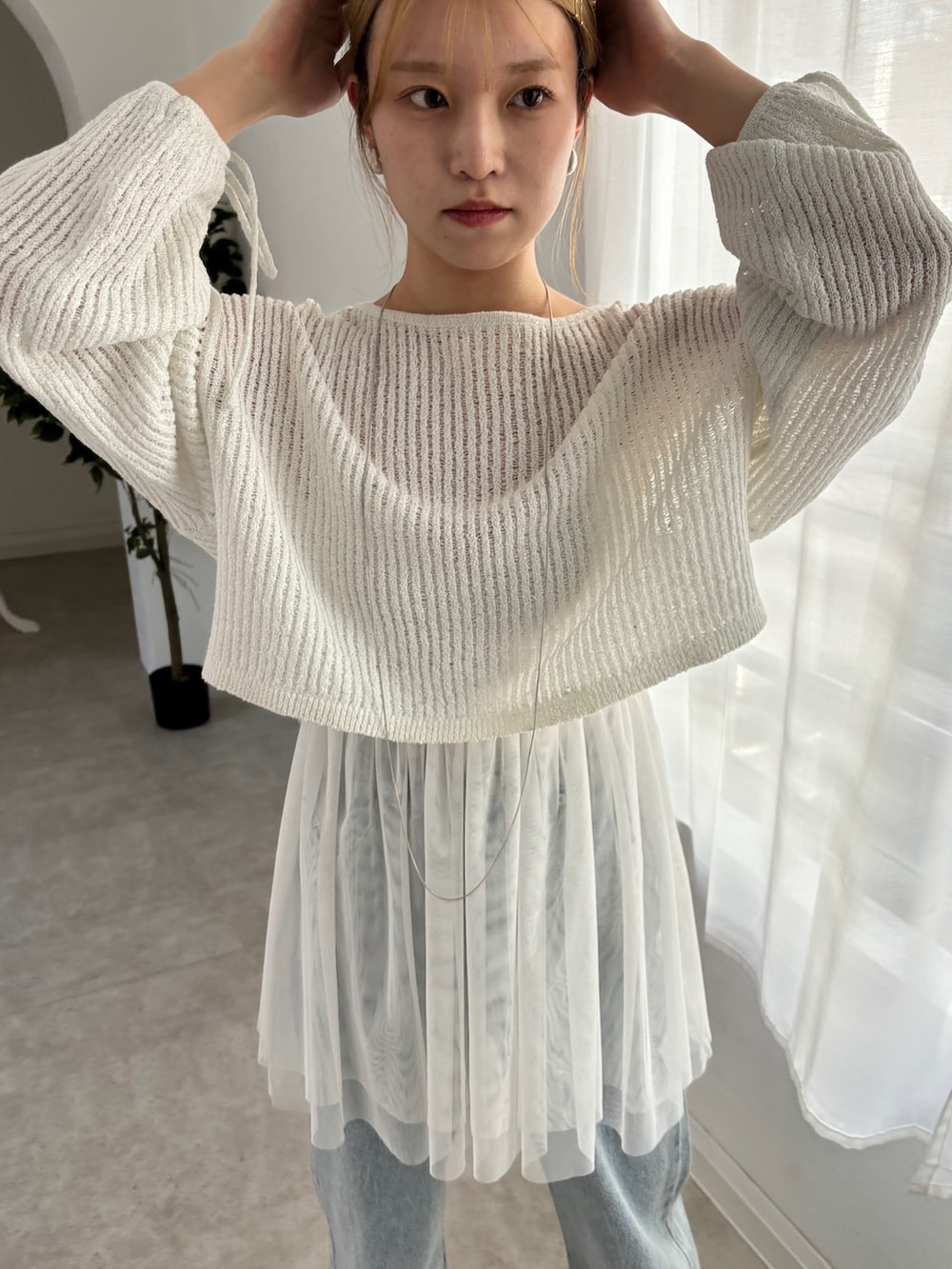 ホワイト系のシャツ/ブラウス、ホワイト系のニット/セーター、ブルー系のデニムパンツを着用したレディースの春コーディネートの5枚目の写真