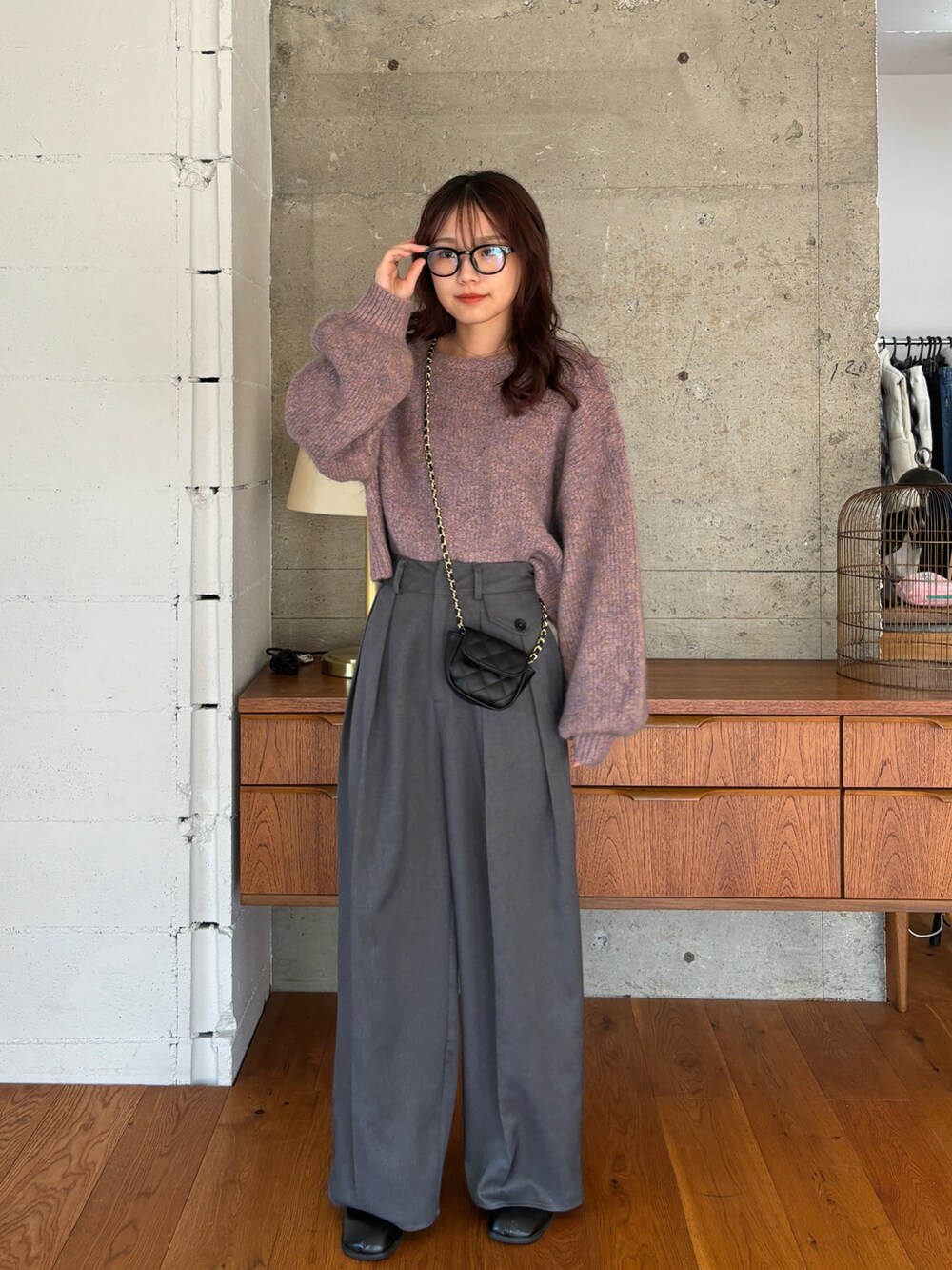 ピンク系のニット/セーター、グレー系のスラックス、ブラック系のブーツを着用したレディースの秋コーディネートの2枚目の写真