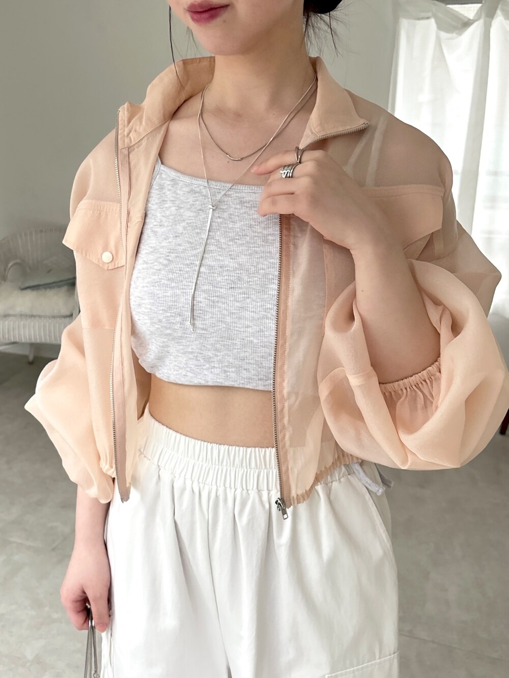 ホワイト系のカーゴパンツ、ホワイト系のスニーカー、ベージュ系のタンクトップを着用したレディースの春コーディネートの5枚目の写真