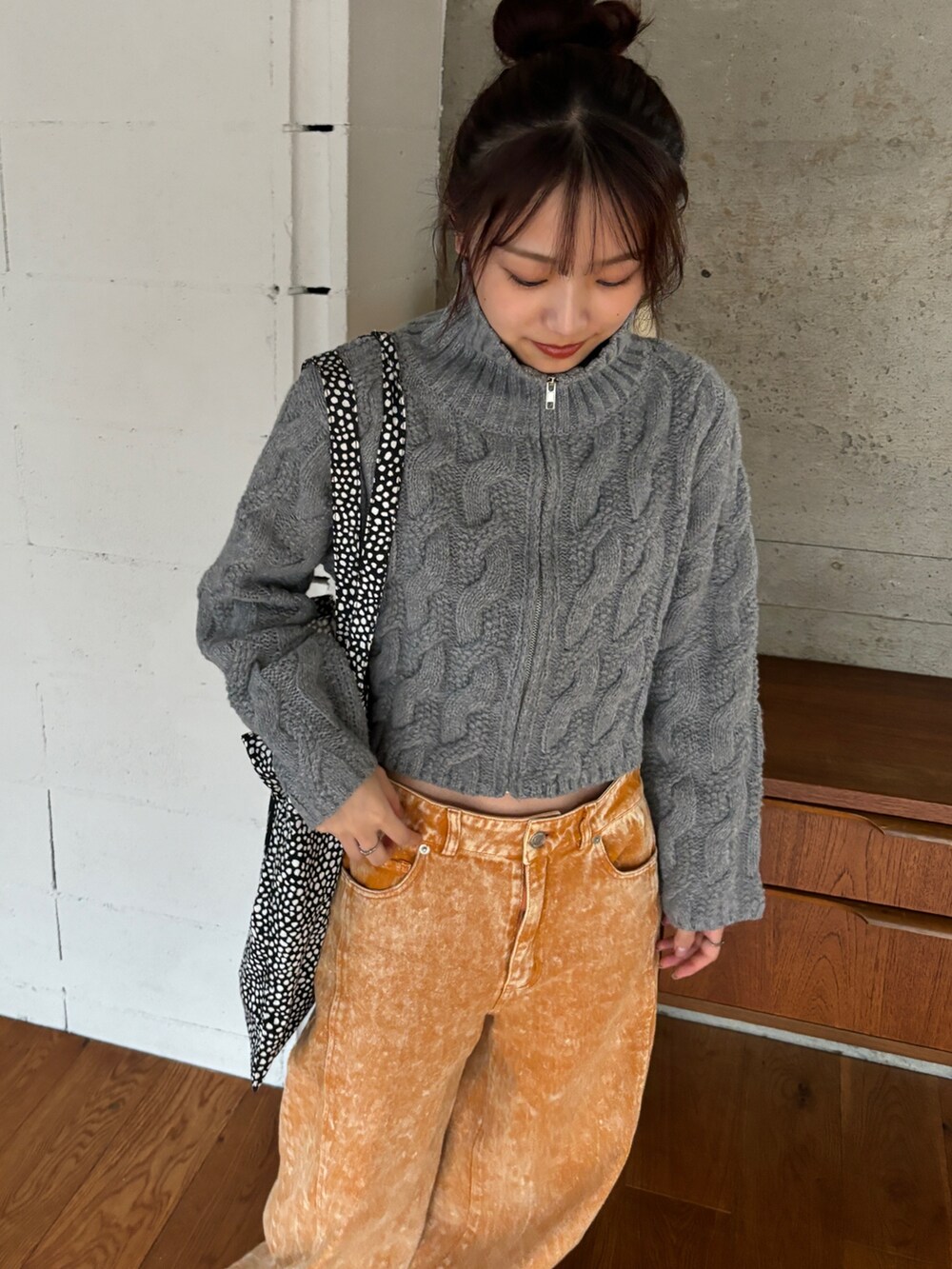 ホワイト系のニット/セーター、オレンジ系のデニムパンツ、ホワイト系のスニーカーを着用したレディースの秋コーディネートの4枚目の写真