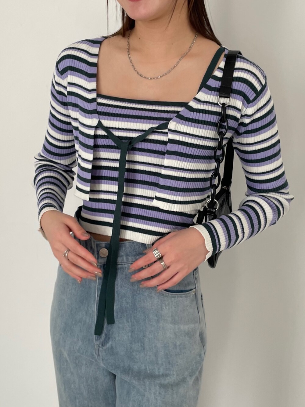 ホワイト系のカーゴパンツ、ホワイト系のスニーカー、パープル系のカーディガン/ボレロを着用したレディースの冬コーディネートの3枚目の写真