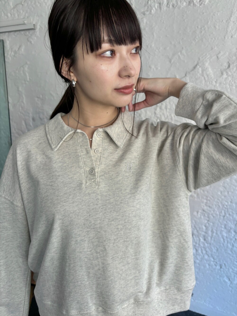 ブラック系のスカート、ホワイト系のスニーカー、ベージュ系のポロシャツを着用したレディースの冬コーディネートの6枚目の写真