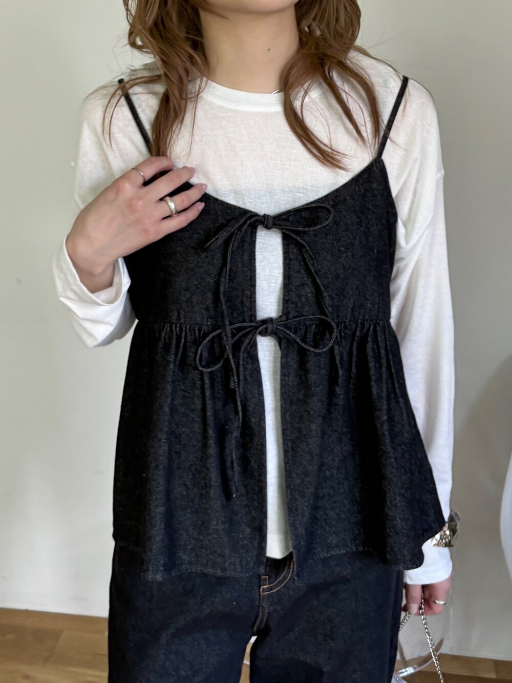 ブラック系のキャミソール、ホワイト系のTシャツ/カットソー、ブラック系のデニムパンツを着用したレディースの春コーディネートの3枚目の写真