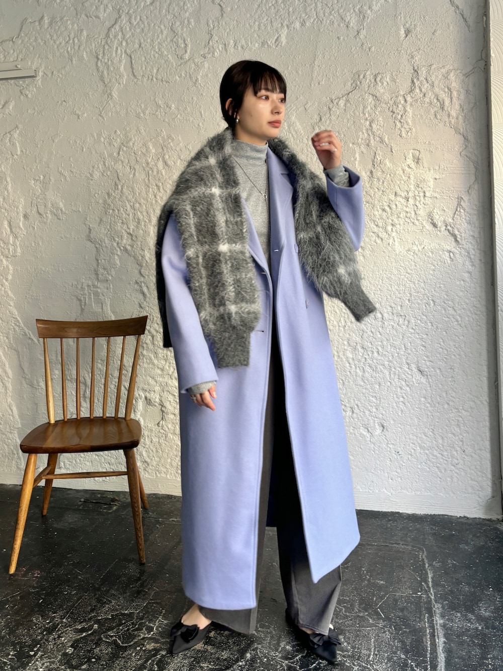 ブルー系のチェスターコート、ブラック系のカーディガン/ボレロ、グレー系のスラックスを着用したレディースの冬コーディネートの2枚目の写真