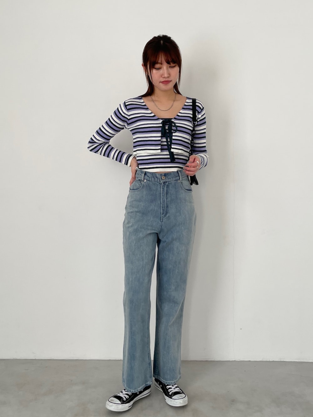 ホワイト系のカーゴパンツ、ホワイト系のスニーカー、パープル系のカーディガン/ボレロを着用したレディースの冬コーディネートの2枚目の写真