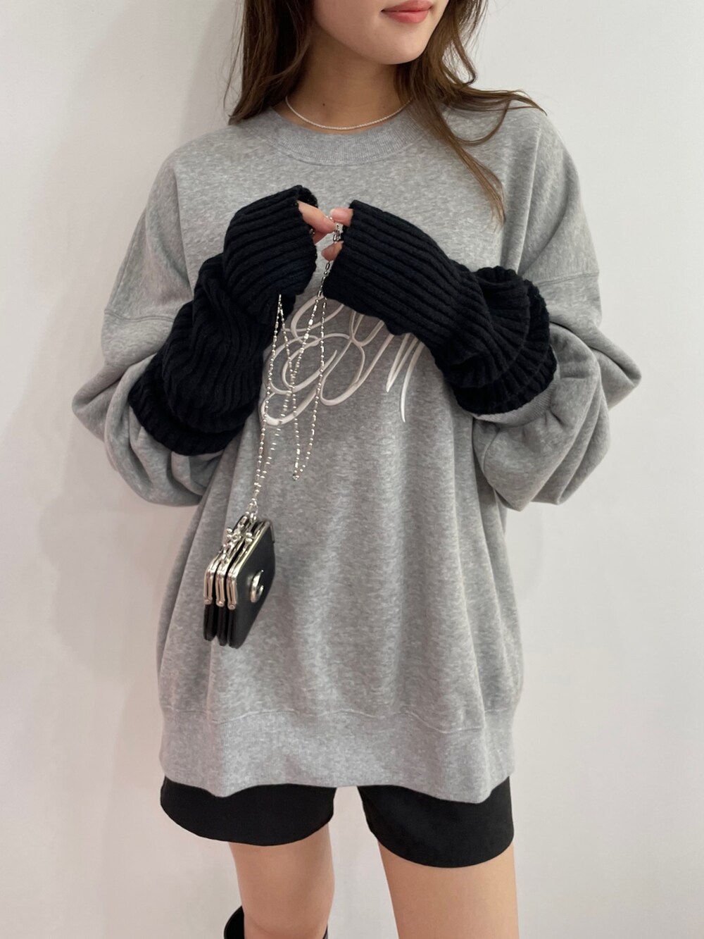 グレー系のスウェット、ブラック系のスカート、ブラック系のブーツを着用したレディースの秋コーディネートの3枚目の写真