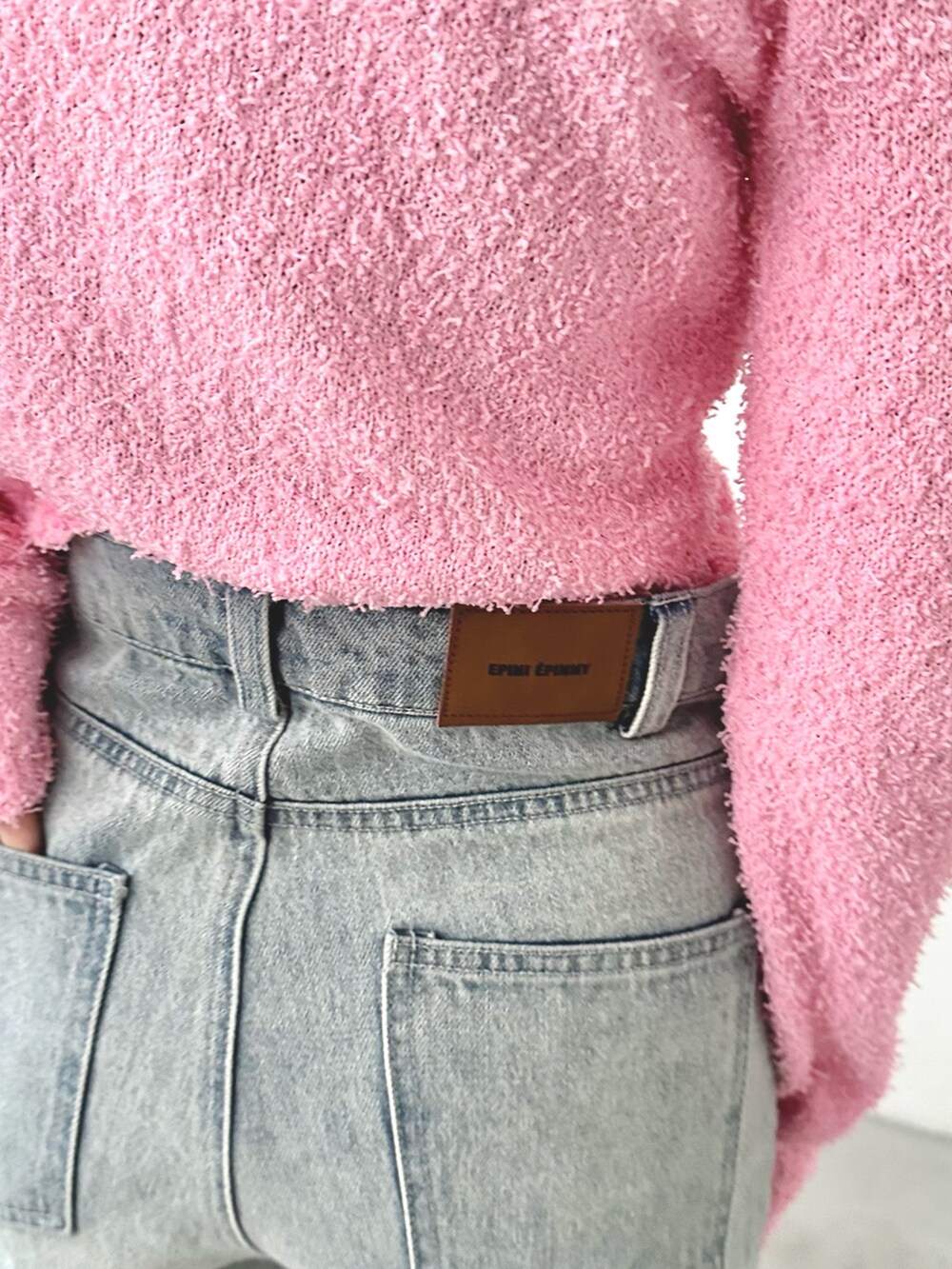 ブルー系のデニムパンツ、シルバー系のバレエシューズ、ピンク系のカーディガン/ボレロを着用したレディースの秋コーディネートの5枚目の写真