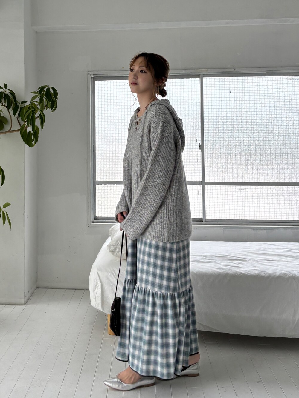 グレー系のニット/セーター、ブルー系のワンピース、ブラック系のショルダーバッグを着用したレディースの夏コーディネートの2枚目の写真