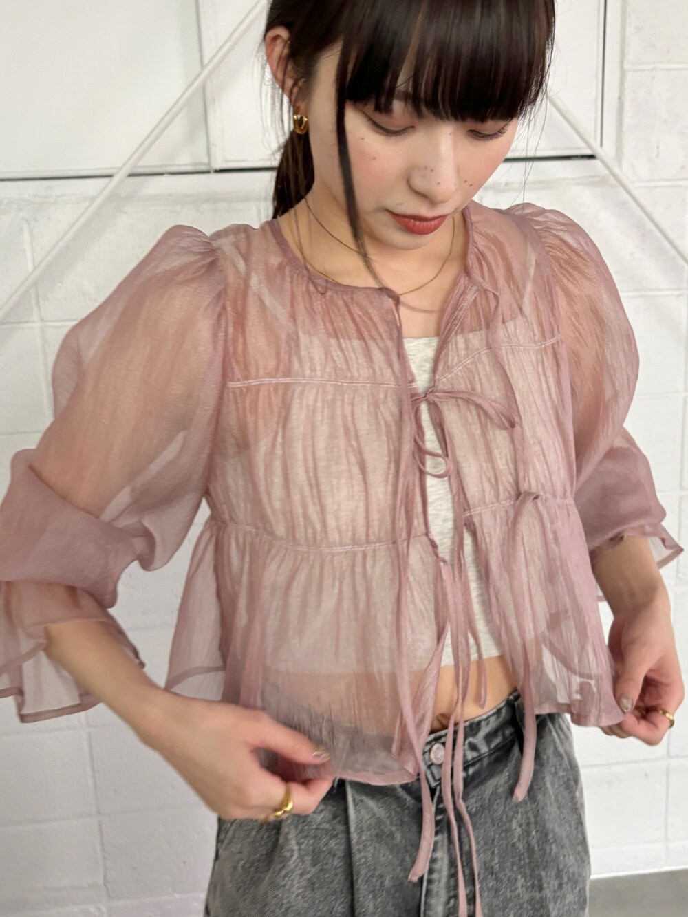 グレー系のデニムパンツ、ピンク系のシャツ/ブラウス、ベージュ系のキャミソールを着用したレディースの春コーディネートの5枚目の写真