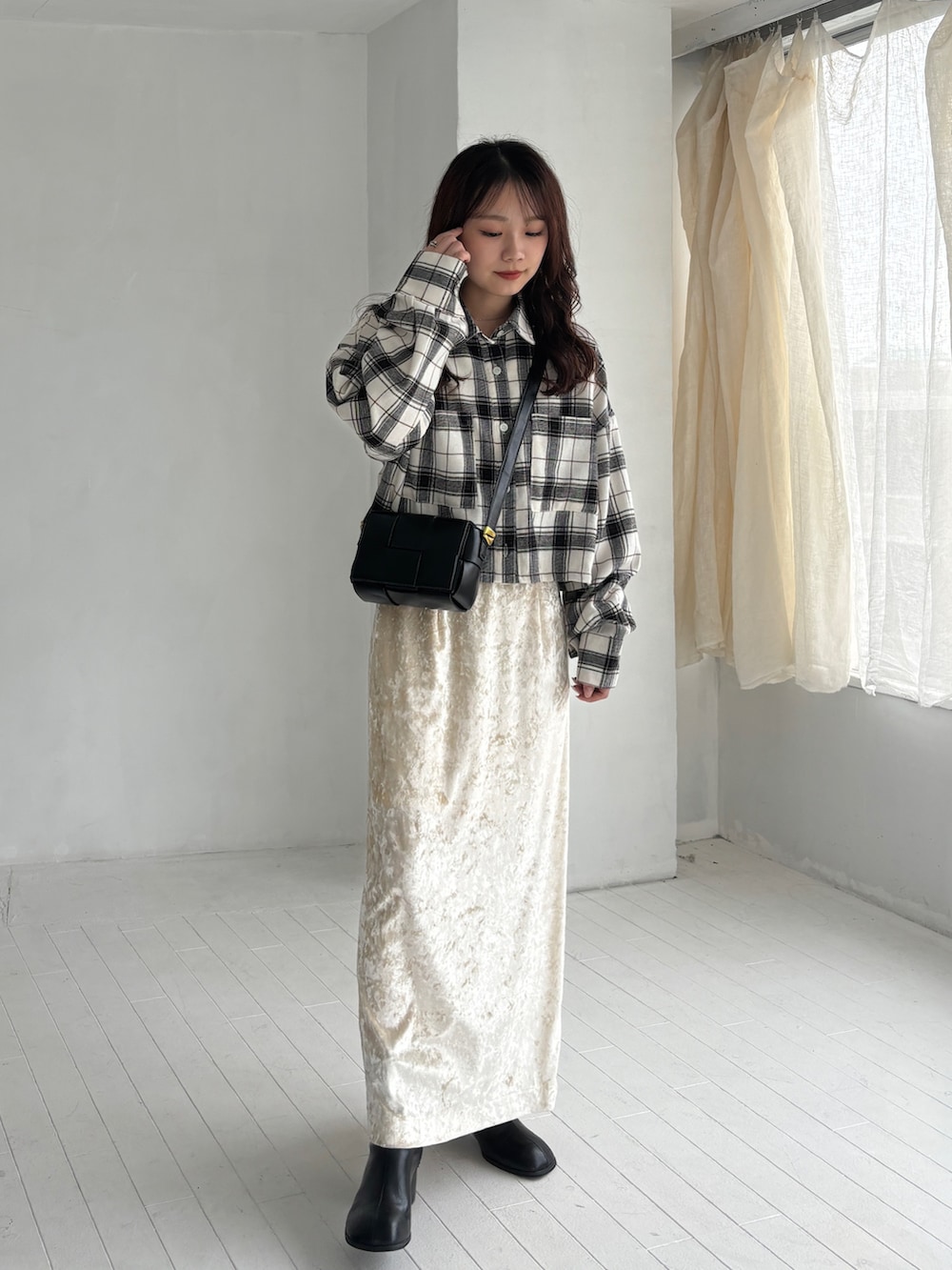 ホワイト系のシャツ/ブラウス、ベージュ系のスカート、ブラック系のブーツを着用したレディースの秋コーディネートの2枚目の写真