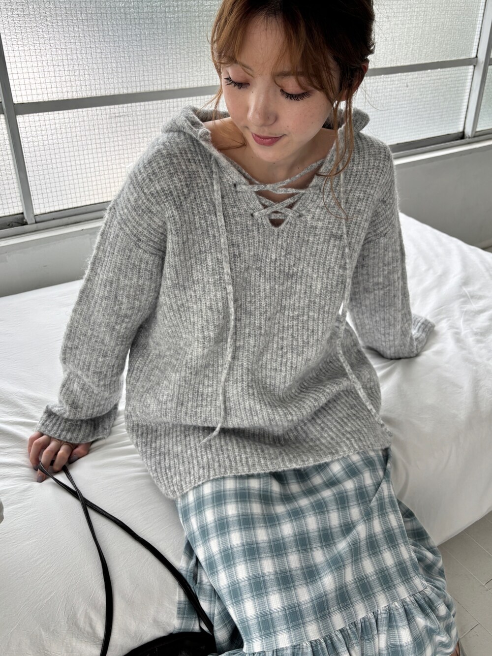 グレー系のニット/セーター、ブルー系のワンピース、ブラック系のショルダーバッグを着用したレディースの夏コーディネートの4枚目の写真