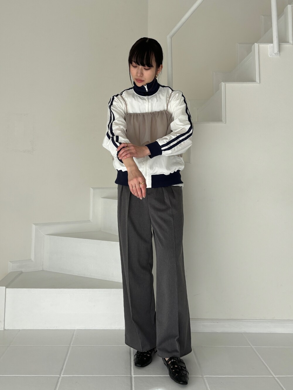 グレー系のトレンチコート、ホワイト系のその他アウター、グレー系のスラックスを着用したレディースの冬コーディネートの5枚目の写真