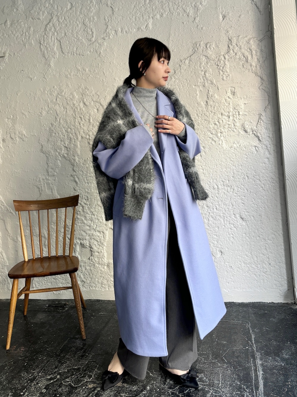 ブルー系のチェスターコート、ブラック系のカーディガン/ボレロ、グレー系のスラックスを着用したレディースの冬コーディネートの3枚目の写真