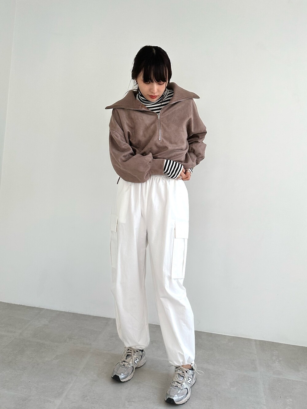 ホワイト系のカーゴパンツ、ブラウン系のTシャツ/カットソー、ホワイト系のニット/セーターを着用したレディースの秋コーディネートの2枚目の写真