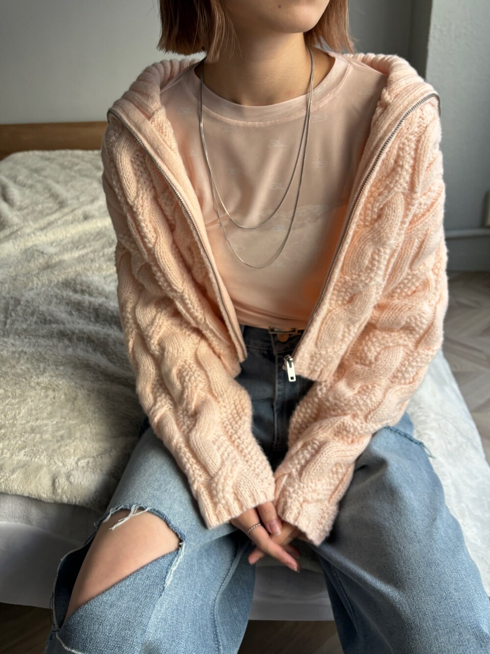 ピンク系のカーディガン/ボレロ、ピンク系のTシャツ/カットソー、ブルー系のデニムパンツを着用したレディースの冬コーディネートの5枚目の写真