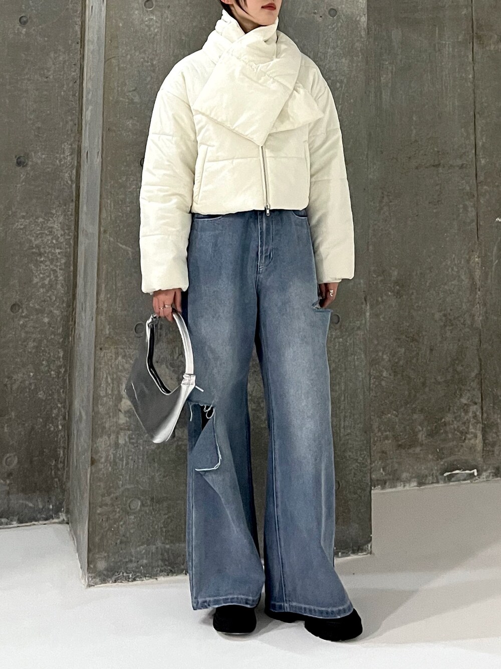 ブルー系のデニムパンツ、ブラック系のスニーカー、ホワイト系のダウンジャケット/コートを着用したレディースの冬コーディネートの2枚目の写真