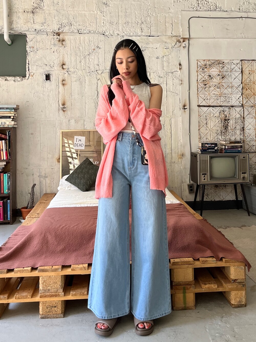 ベージュ系のタンクトップ、ブルー系のデニムパンツ、ピンク系のカーディガン/ボレロを着用したレディースの春コーディネートの2枚目の写真