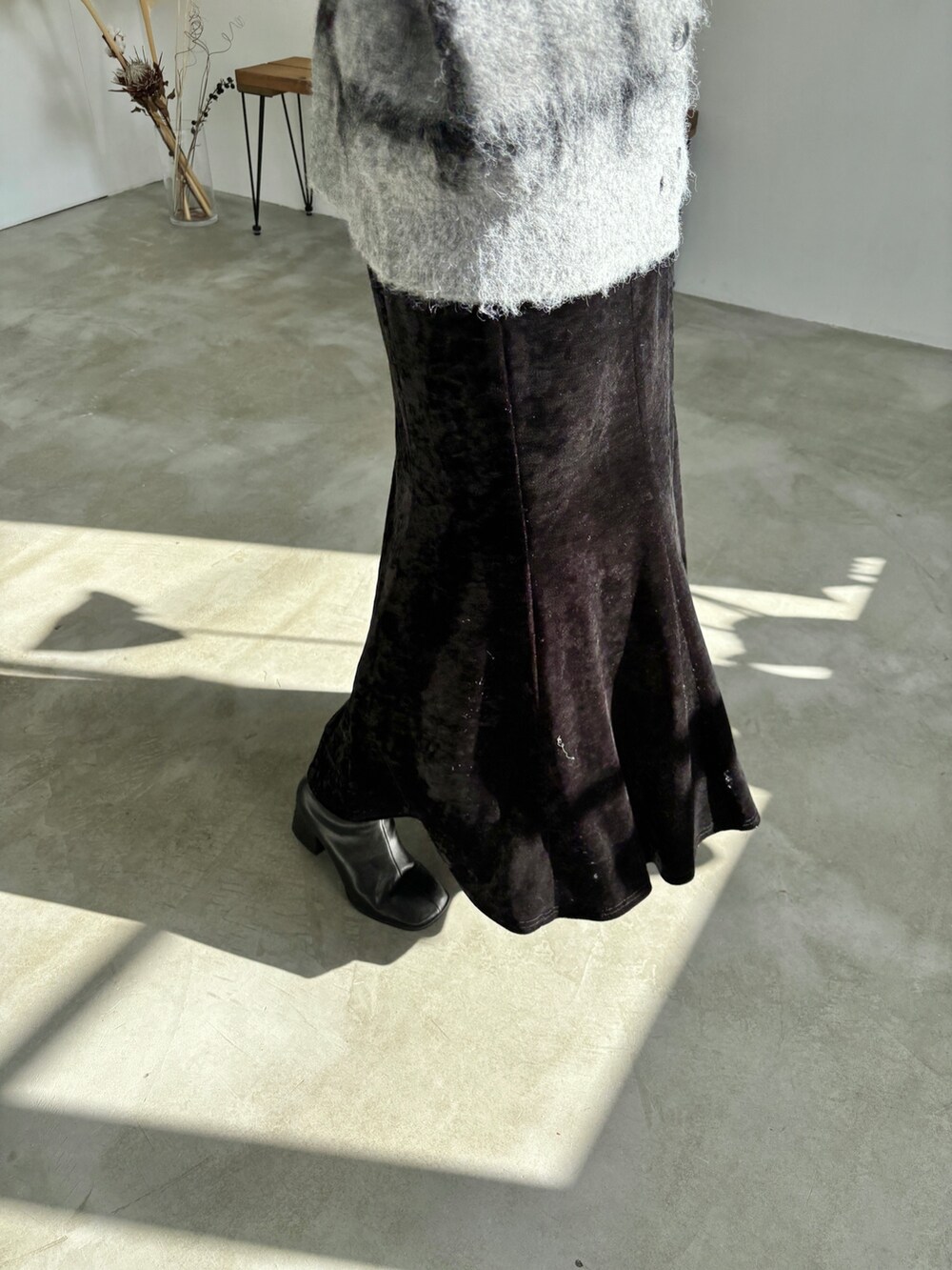 ブラック系のワンピース、グレー系のカーディガン/ボレロ、ブラック系のブーツを着用したレディースの冬コーディネートの6枚目の写真