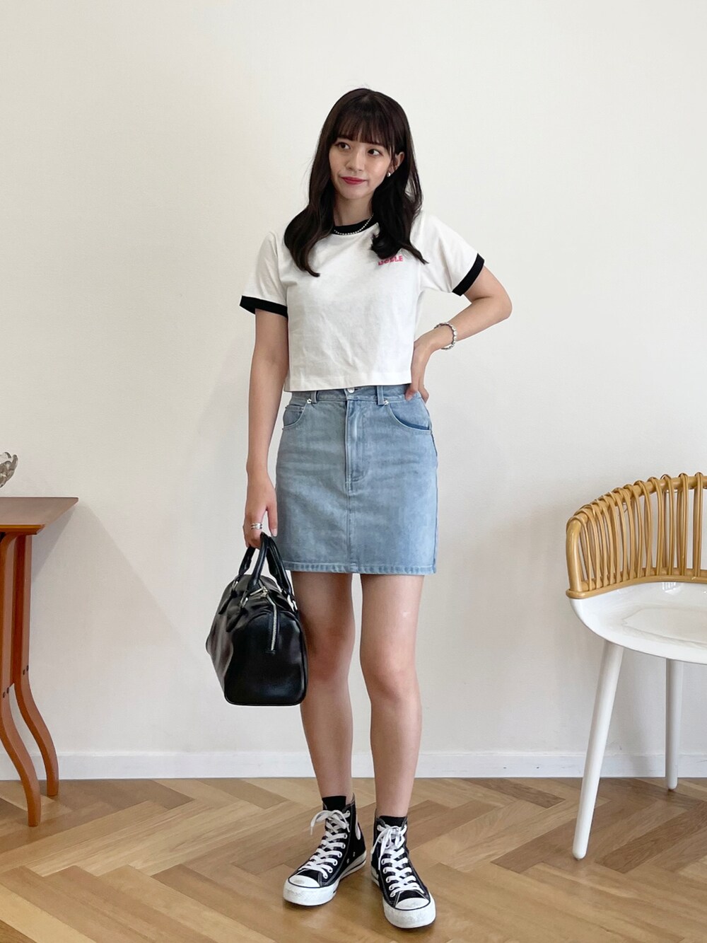 ブラック系のボストンバッグ、ブルー系のデニムスカート、ブラック系のスニーカーを着用したレディースの夏コーディネートの3枚目の写真