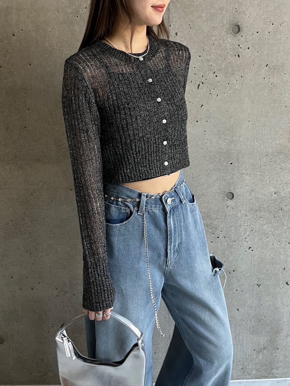 ブルー系のデニムパンツ、ブラック系のカーディガン/ボレロ、ホワイト系のスニーカーを着用したレディースの春コーディネートの4枚目の写真