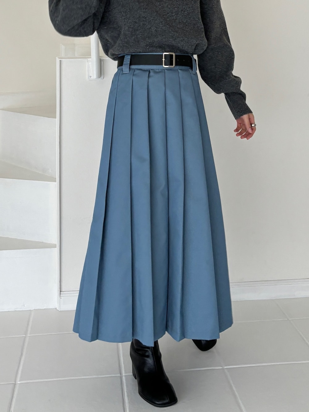 ブルー系のスカート、グレー系のニット/セーター、ブラウン系のブーツを着用したレディースの冬コーディネートの4枚目の写真