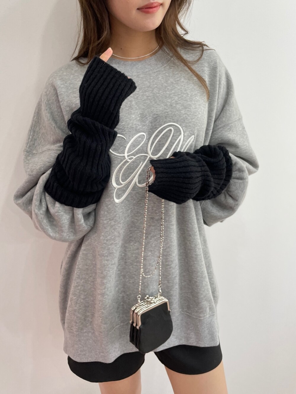 グレー系のスウェット、ブラック系のスカート、ブラック系のブーツを着用したレディースの秋コーディネートの4枚目の写真