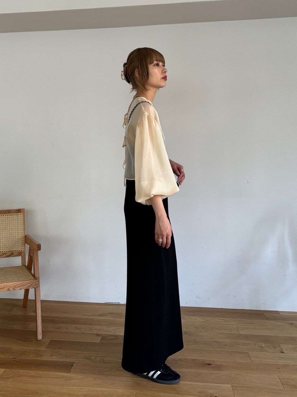 ブラック系のワンピース、ベージュ系のシャツ/ブラウスを着用したレディースの春コーディネートの2枚目の写真