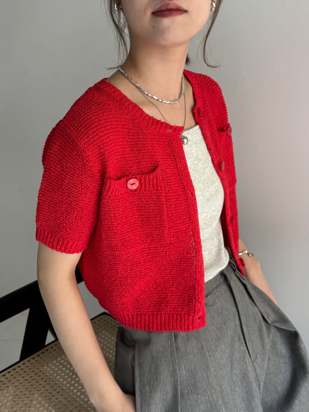 グレー系のスラックス、レッド系のカーディガン/ボレロ、ベージュ系のキャミソールを着用したレディースの夏コーディネートの4枚目の写真