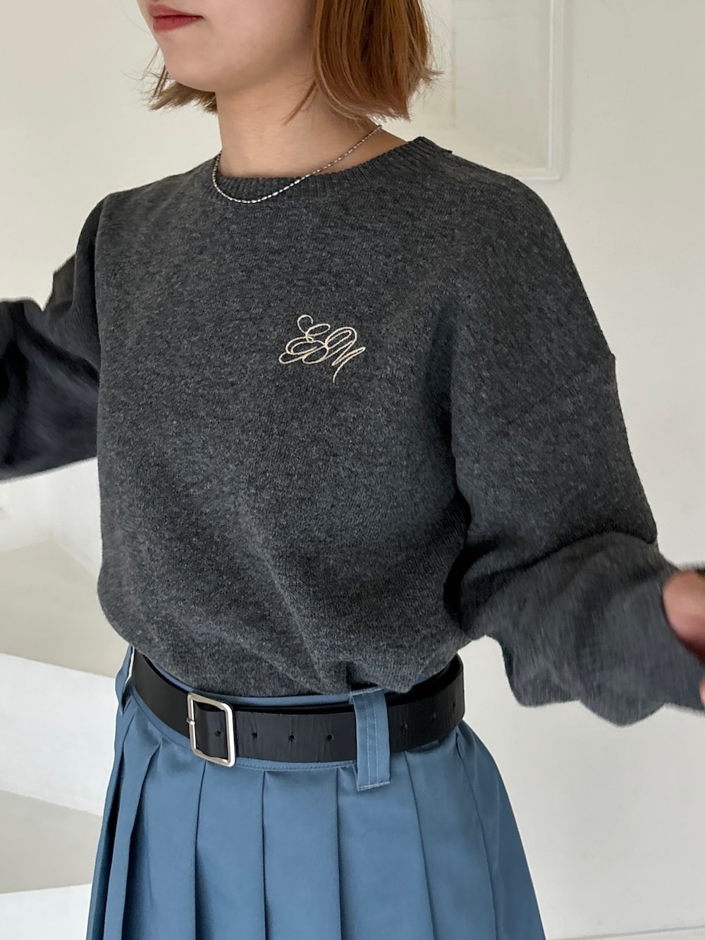 ブルー系のスカート、グレー系のニット/セーター、ブラウン系のブーツを着用したレディースの冬コーディネートの3枚目の写真